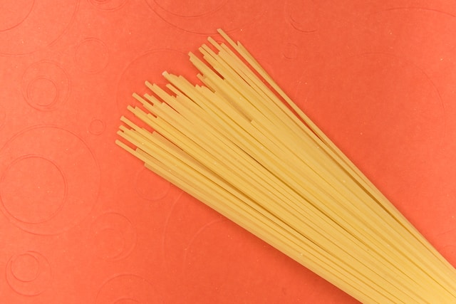 Dried spaghetti on an orange background