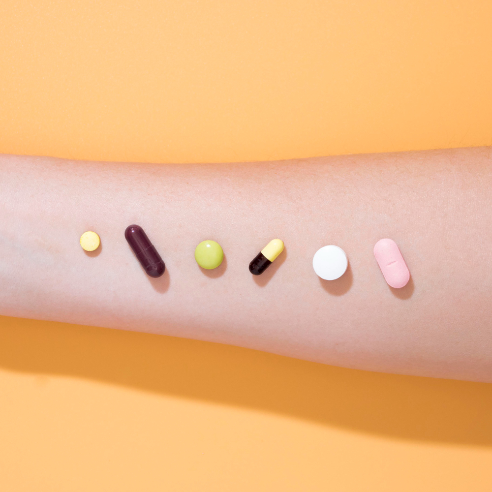 Various pills arranged on a forearm